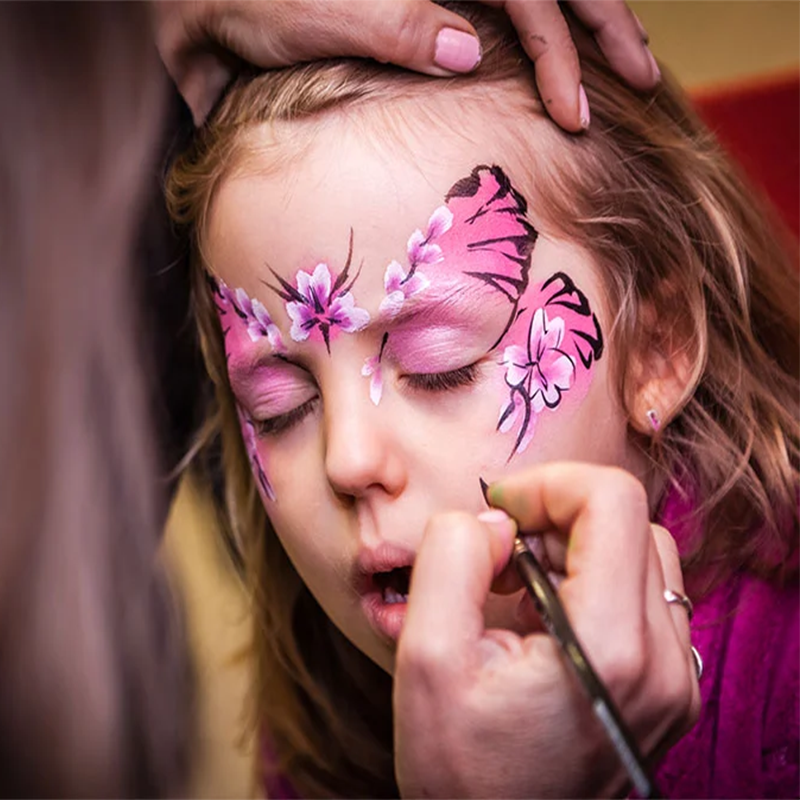 Happy children with colorful face paint designs at a birthday party.