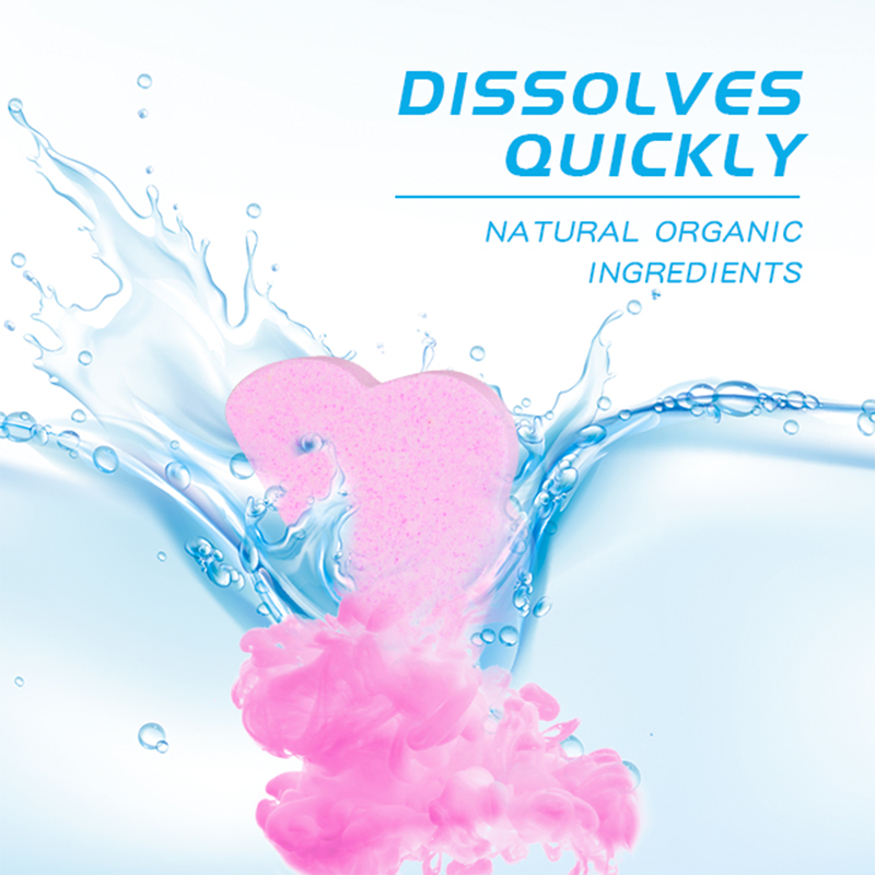 A close-up of a child's hand dropping a Kids Bath Bomb into a bubbly bath, with the water turning a bright, playful color.