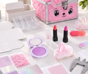 Kids makeup products, packaging dielines, insert sample, material swatches, and caliper on a product-development desk